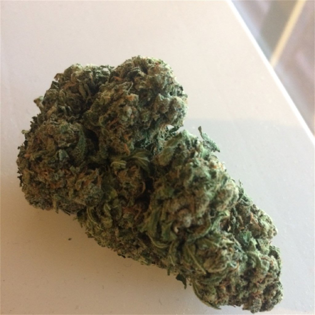 hanfsamen-heavy-bud-feminisierte-advanced-seeds-7-1.jpg Nahaufnahme von getrockneten Cannabis-Blüten mit detaillierter Textur auf einer weißen Oberfläche.